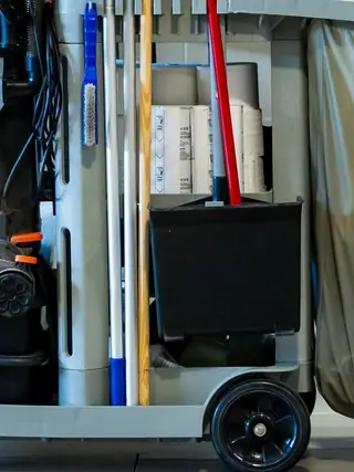 Professional cleaning cart stocked with buckets, bottles, mops and other janitorial supplies.