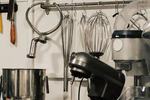 Industrial mixers and preparation tools arranged in a commercial kitchen.